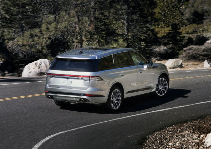 A 2023 Lincoln Aviator® Grand Touring model is shown being driven on a tight turn of a mountain road | Holmes Tuttle Lincoln in Tucson AZ